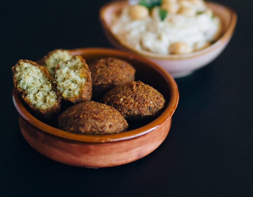 close up photo of fried falafels in a brown bowl