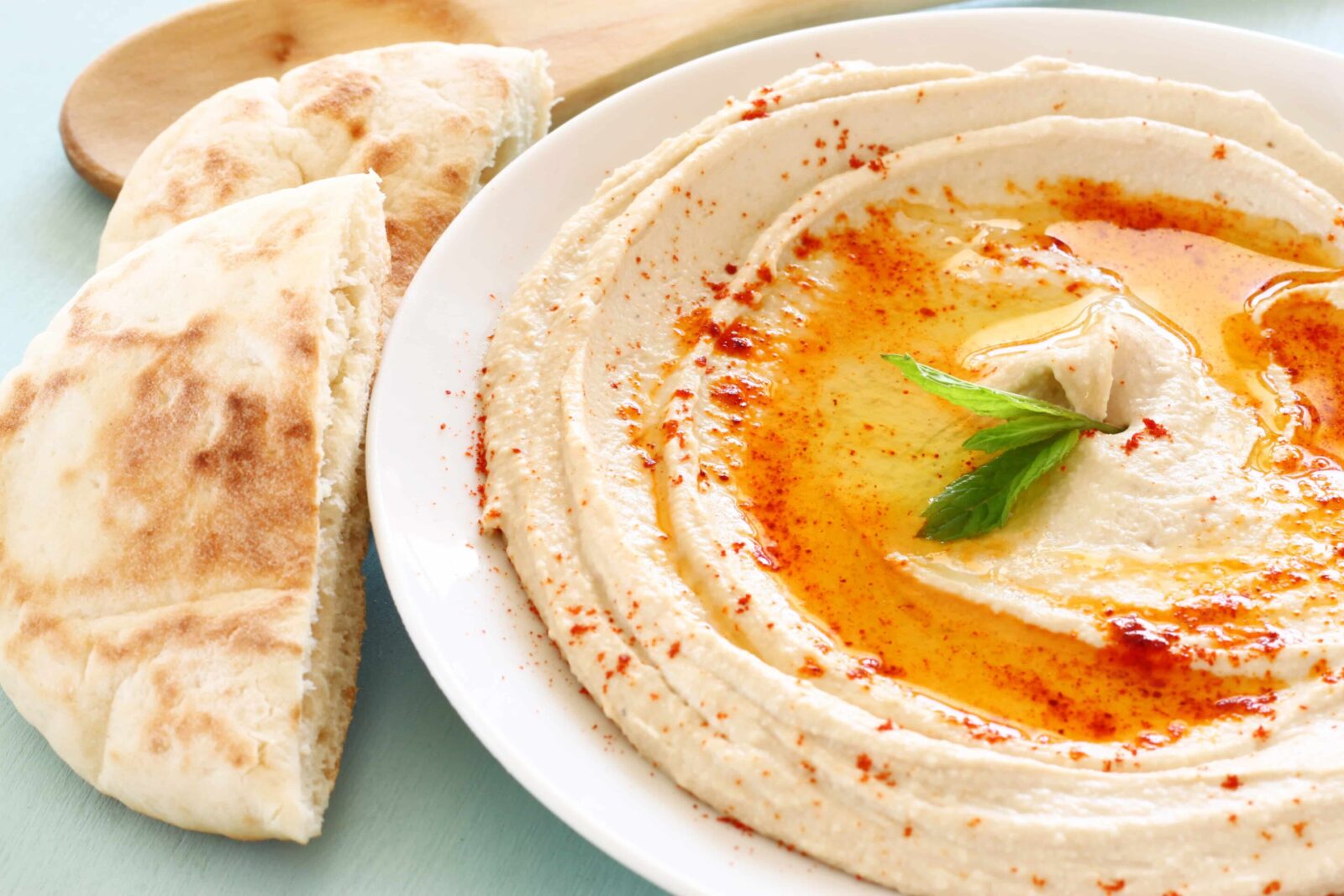 hummus served on a white plate along with bread