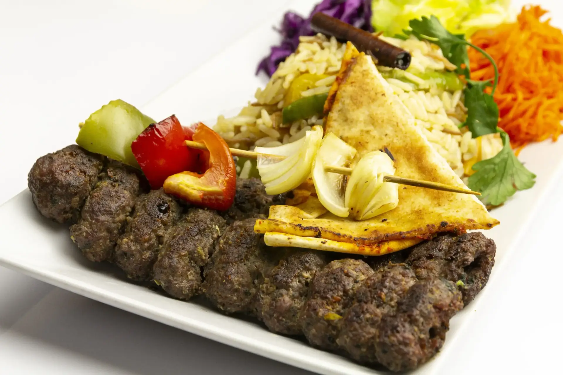 Close-up of chargrilled kabobs served with saffron rice