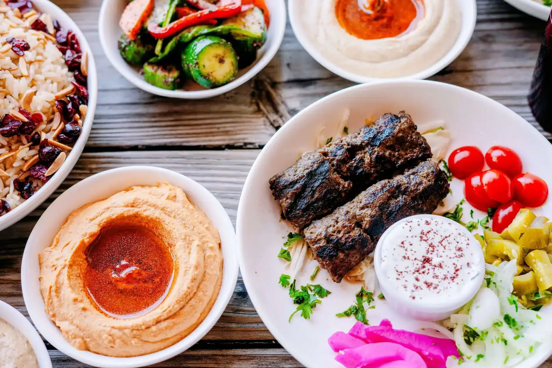 Table with almond rice vermicelli, kafta and spicy hummus at Aladdin Montrose