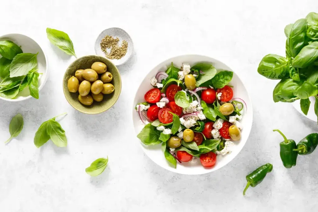 Fresh Mediterranean salad with cherry tomatoes, olives, basil leaves, and feta, perfect for vegan Mediterranean recipes