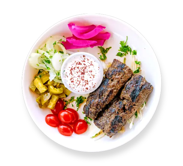 Kafta kabob skewers served over rice with grilled vegetables at Aladdin Mediterranean Cuisine in Houston
