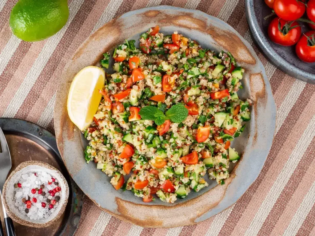 "Colorful tabbouleh salad with quinoa, tomatoes, cucumbers, and fresh herbs, a staple in vegan Mediterranean recipes