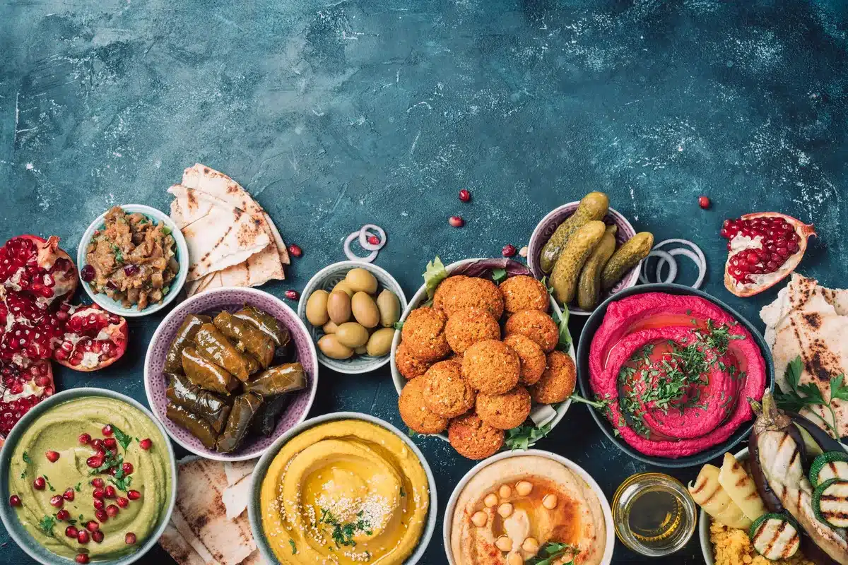 Assorted traditional Middle Eastern mezze with hummus, falafel, grape leaves, and vibrant dips, perfect for vegan Mediterranean recipes.