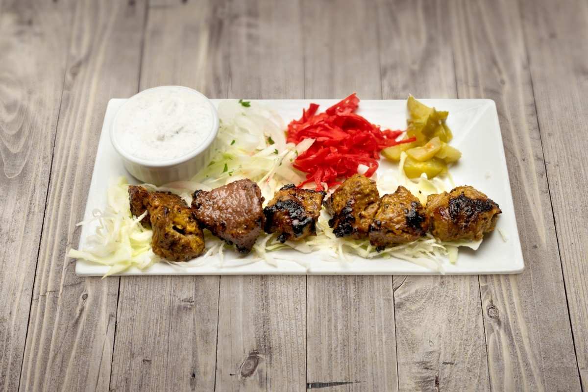 Grilled Mediterranean beef kebab with tzatziki, pickles, and salad — a high-protein a Key component of Mediterranean diet meal from Aladdin Mediterranean Grill in Houston