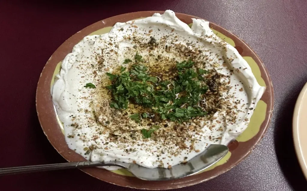 Labneh, a creamy and topped with herbs and olive oil. One of the best Mediterranean dips you can try.