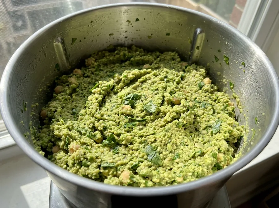Coarsely ground bright green falafel mixture in a food processor